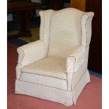 A vintage upholstered armchair, raised on mahogany supports,