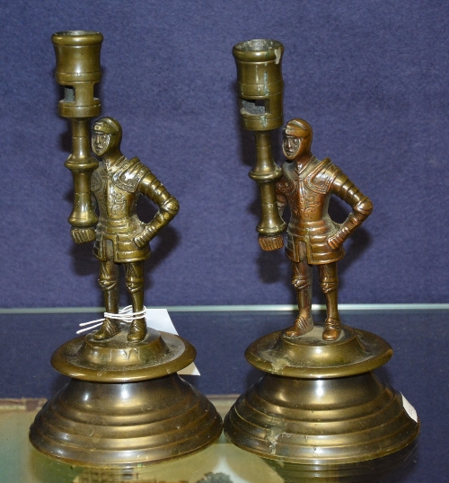 A pair of cast bronze candlesticks in the form of Centurions, raised on circular bases,