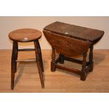 An oak jointed drop leaf table, with swivel top raised on turned block columns, 48cm high x 57.