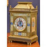 A brass mantel clock circa early 20th century, with enamel dial and panels,
