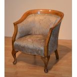 A floral upholstered armchair raised on cabriole supports,