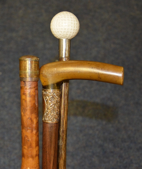 Three walking sticks, one with horn handle and rolled gold collar, one enclosing a yard stick,