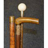 Three walking sticks, one with horn handle and rolled gold collar, one enclosing a yard stick,