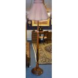 A mahogany floor lamp with shade, raised on circular base,