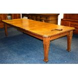 An early 20th century oak extending dining table, with two additional leaves,