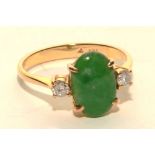 A 14ct gold jade and diamond ring, the central oval green jade cabochon (approx 1.