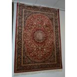 A Keshan style machine made carpet, the central star medallion over red ground,