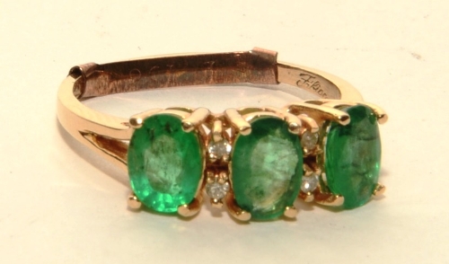 A 14ct gold emerald and diamond ring, with three oval cut emeralds (approx 1.