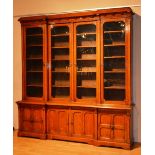 A large Victorian oak library bookcase, the moulded cornice with carved motifs above glazed doors,