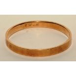 A 9ct gold bangle, inscribed with initials 'JRM' to inside, stamped 9ct, 6.5cm diameter, 12.