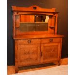 An Arts & Crafts oak mirror back sideboard, with mirrored top section,