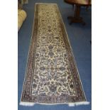 A Keshan runner, the navy foliate motif over cream ground, with cream and brown floral border,