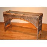 A wicker conservatory glass top side table,