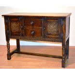 A Jacobean style oak sideboard, with two drawers, flanked by a panelled door,