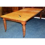 A late 19th/early 20th century oak extending dining table, with three additional leaves,