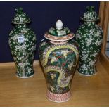 A pair of Chinese pottery vases with covers, decorated with trees in foliage on green ground, 32cm,