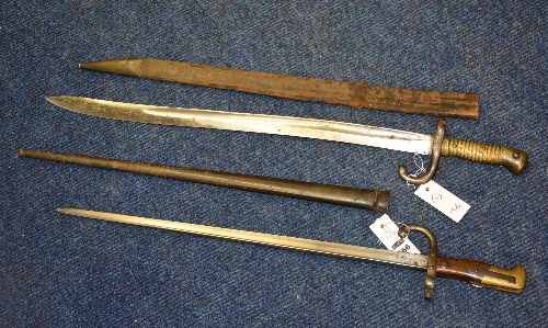 Two 19th century French bayonets, with leather and metal scabbard, 52cm x 56.