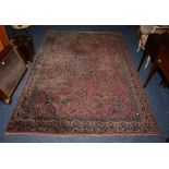 An Eastern rug, the central navy medallion over pink ground, with allover foliate motif and cream,