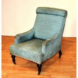 A Victorian green upholstered armchair, raised on turned ebonised support with castors,