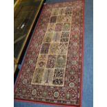 An Eastern style rug, the central brown and beige design on navy ground,