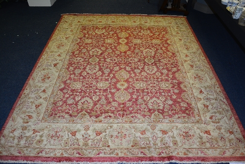 A Persian carpet, the overall cream floral motif over red ground, with cream and red border,