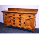 An Arts & Crafts oak sideboard retailed by John Taylor & Sons Edinburgh,