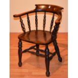 A late 19th/early 20th century stained beech captains armchair, with scroll frame,