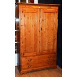 A modern pine wardrobe, with two panelled doors, above two long drawers,