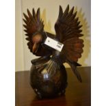 A Black Forest style solid carved wood figure of an eagle on globe, with wings aloft,