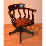 A Victorian oak Captains swivel armchair, with scroll arm rests and leather seat,