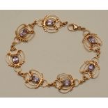 A 9ct gold amethyst bracelet, the seven foliate roundels each set with central oval cut amethyst,