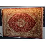 A Kashan carpet, with floral motifs on red ground,