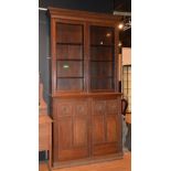 An Edwardian oak bookcase on cupboard base,