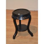 A Chinse ebonised jardiniere stand, with circular top above Chinese symbols to the frieze,