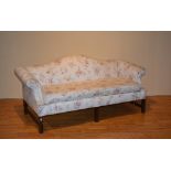 A mahogany framed humpback settee, upholstered in later floral fabric,