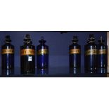 A set of six Victorian blue glass chemist bottles with stoppers, all bearing gilt name labels,