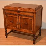 An oak gramophone cabinet, in working condition, with hinged top above two panelled doors,