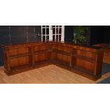 A reproduction mahogany two section corner bookcase, enclosing fitted shelves,