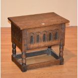 An early 20th century Jacobean style jointed oak stool, with hinged top,