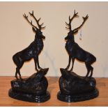 A pair of large cast bronze figures of stags, raised on marble bases,