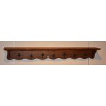 A French oak hat & coat wall mounting rack, with seven metal mask decorated pegs,