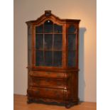 A reproduction Dutch style walnut bookcase on bombe chest,