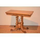 A Victorian birds eye maple fold over card table, raised on fluted and turned columns,