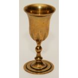 An 18th century brass communion cup, engraved WBM to underside, terminating on circular foot,