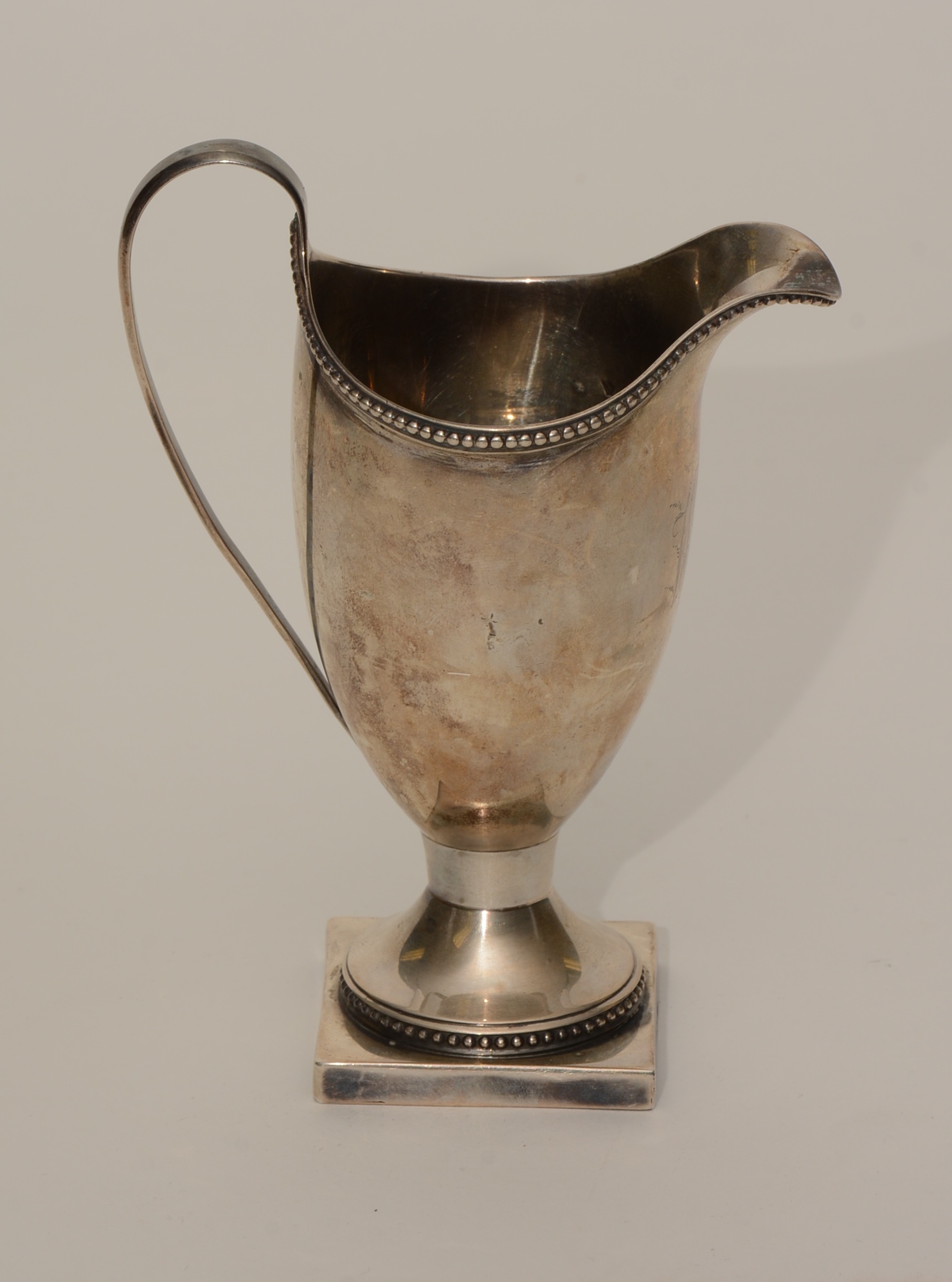 An 18th century silver cream jug, hallmarks for London 1792-93, monogrammed WMB,