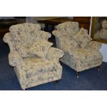 A pair of modern upholstered wing armchairs, upholstered in pale yellow floral fabric,