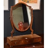 A Regency style toilet mirror, the shield shaped swing mirror raised above three drawer base,