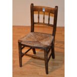 An early 20th century child's spindle back chair, with woven rush seat,