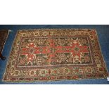 An Eastern rug, the central panel with allover geometric design on red ground,