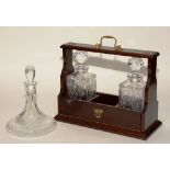 An oak Tantalus with two matching crystal mallet decanters,